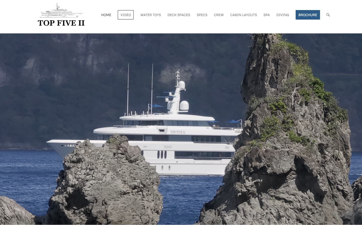 The Top Five II website homepage: the yacht at anchor between rocks, beneath a menu of Video, Water Toys, Deck Spaces, Specs, Crew and Cabin Layouts